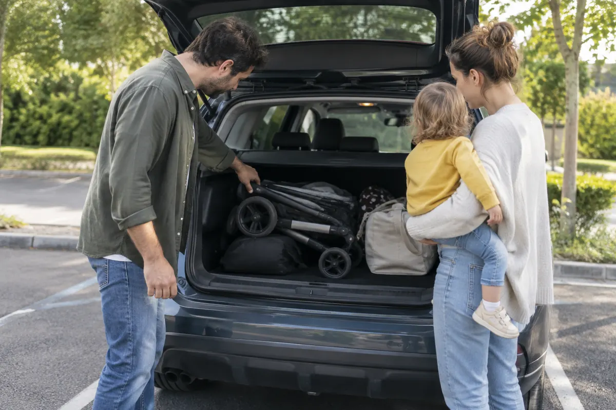 Famille testant le coffre d’une voiture avec une poussette et des bagages